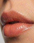 Close-up of glossy lips with a neutral background