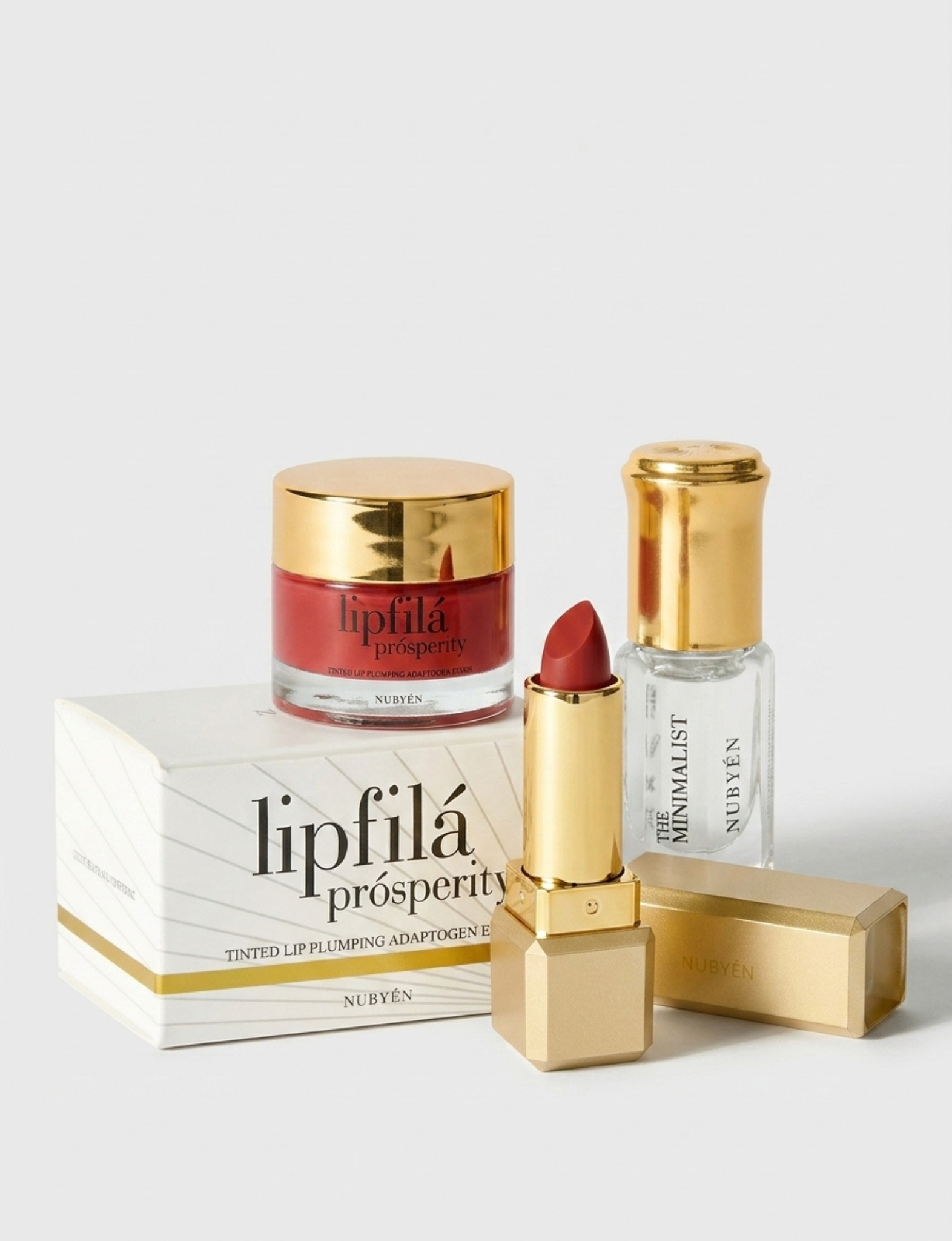A luxury skincare and lip care set featuring a red lipstick, a gold-lidded jar of lipfilá prosperity cream, a clear bottle of the Minimalist Sunscreen, and their white and gold packaging boxes, arranged on a clean white background.