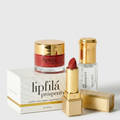 A luxury skincare and lip care set featuring a red lipstick, a gold-lidded jar of lipfilá prosperity cream, a clear bottle of the Minimalist Sunscreen, and their white and gold packaging boxes, arranged on a clean white background.