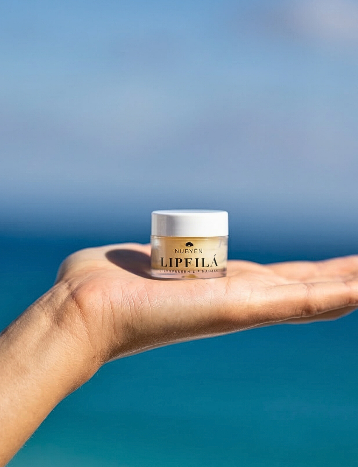 Nubyén Lipfilá lip plumping elixir shown with its white outer box, a gold inner tray, and the open jar placed on top. BEST SELLER