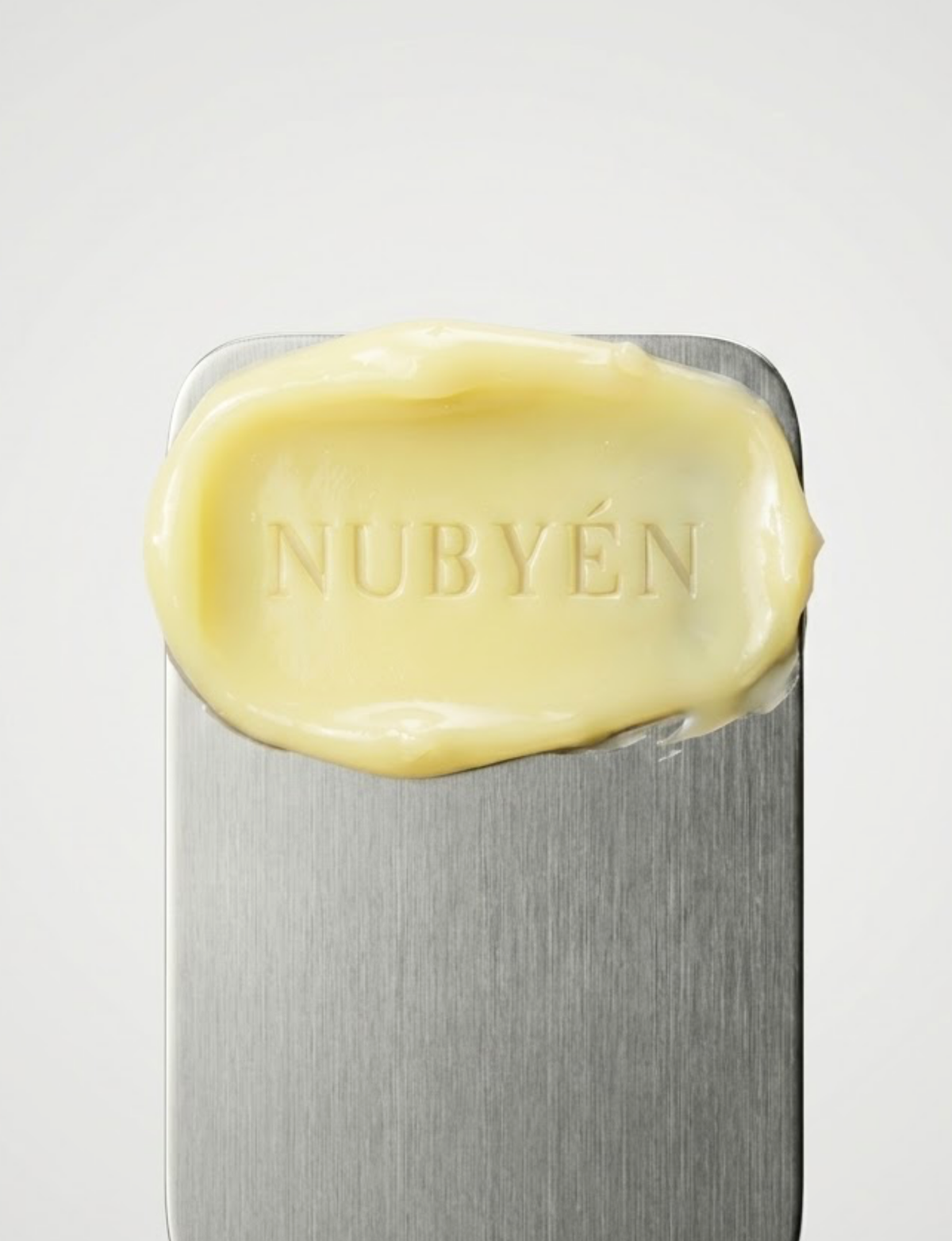 Nubyén Lipfilá lip plumping elixir shown with its white outer box, a gold inner tray, and the open jar placed on top. BEST SELLER