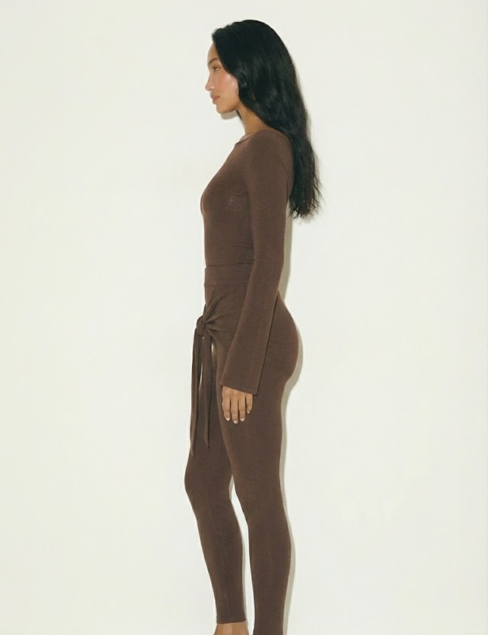 Romy Knit Pants in chocolate brown, featuring a high-waisted fit, soft knit fabric, and a front-tie detail for a stylish and comfortable look. Perfect for casual or elevated cozy outfits

Romy Knit Top styled in a minimalist setting. Featuring a sleek, fitted design with a boat neckline and ribbed texture, it exudes contemporary elegance. Soft lighting and neutral tones enhance its sophisticated appeal."