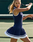 The Nubyen Prosperity Pleated Tennis Dress is a luxury women’s tennis dress designed with a sculpting silhouette, elegant pleated detailing, and elevated performance fabric for refined movement on and off the court. Inspired by contemporary racket sports fashion and minimalist athletic styling, this premium activewear piece blends modern femininity with functional comfort. The streamlined fit enhances confidence and flexibility, making it ideal for tennis, padel, wellness lifestyles, and luxury everyday spo