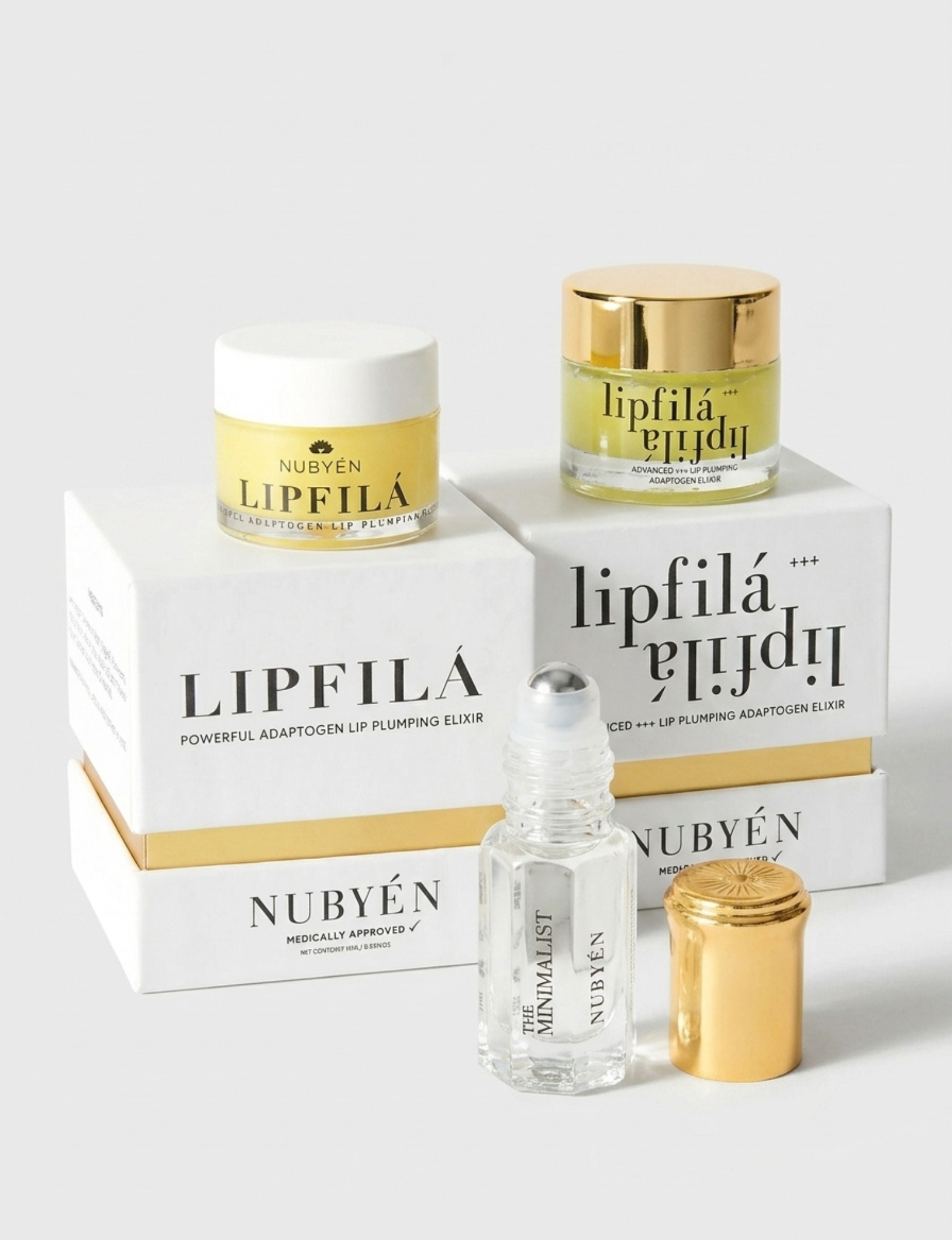 Nubyén Lipfilé cosmetic set featuring a white cream jar with a gold lid, a clear roll-on bottle with a silver cap, and a gold cap, arranged in front of white and gold branded boxes on a light gray background.